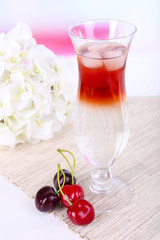 Glass of cocktail on table on light background