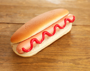 Tasty hot dog on wooden table