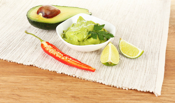 Fresh guacamole in bowl on table