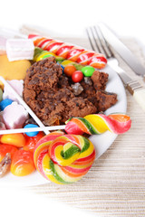 Different sweets on plate on table close-up