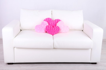 Pink heart shaped pillows on white sofa