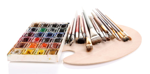 Many brushes on wooden palette, isolated on white