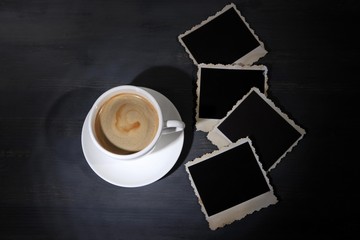 Coffee cup and old blank photos, on wooden background