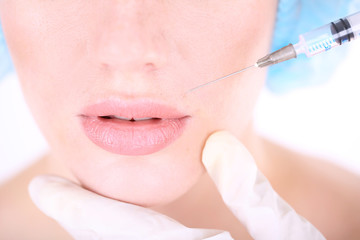 Woman in beauty clinic getting botox injection, isolated