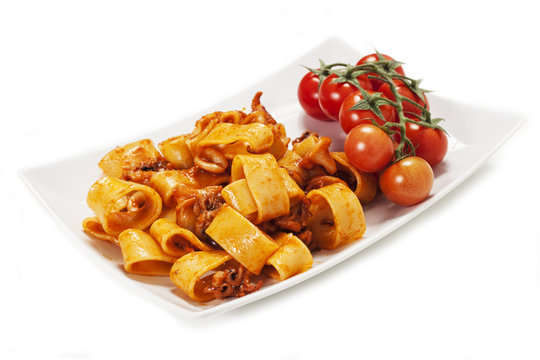 Pasta al sugo di pomodoro con calamari su sfondo bianco