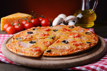 Tasty pizza on table on dark red background