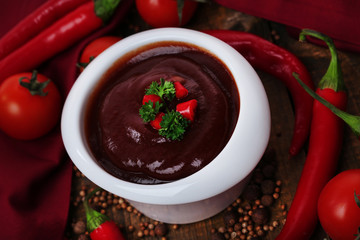 Tomato sauce in bowl on wooden table close-up