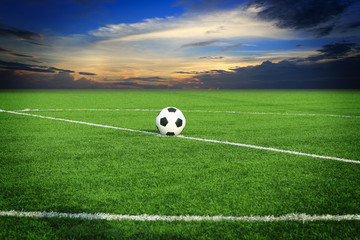 Plakat soccer ball on soccer field with sun set 