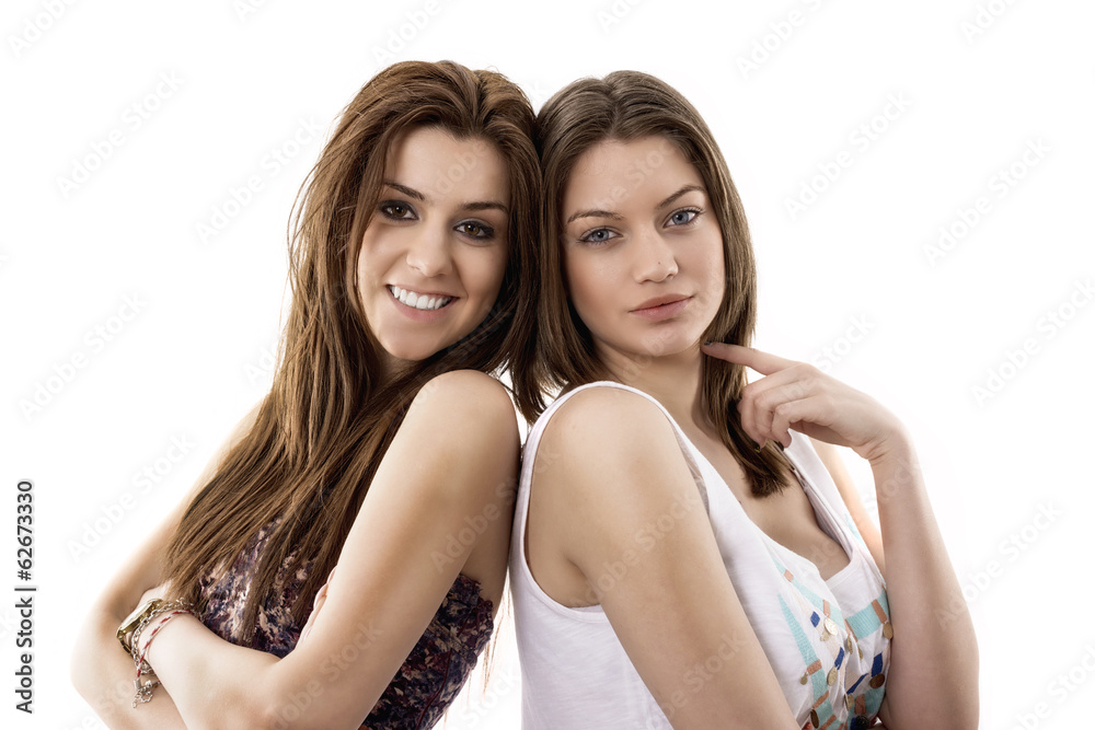 Wall mural close-up portrait of two smiling young female friends against wh