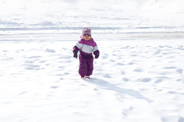 Fototapeta na wymiar Little girl walking in the snow