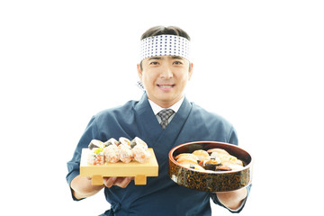 寿司を差し出す笑顔の寿司職人