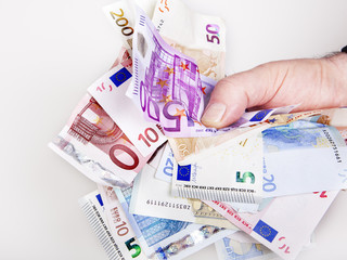 Hand holds bunch of crumpled cash