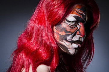 Woman with face painting in dark room