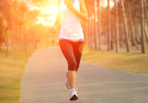 fitness woman runner running at sunrise tropical park