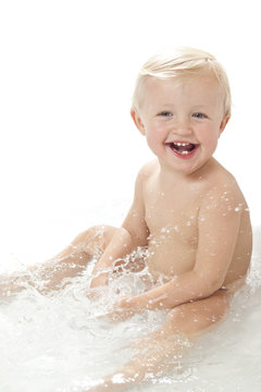 Baby splashing water in bath
