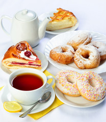 still life of setout table with baking pies, donuts, tee cup and