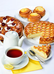 still life of setout table with baking pies ant tee cup and pot.