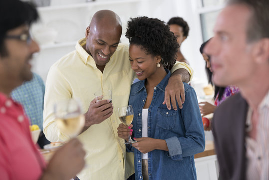 Networking Party Or Informal Event. A Man And Woman, With A Crowd Around Them.