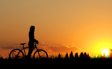 Mountain biker girl silhouette in sunset