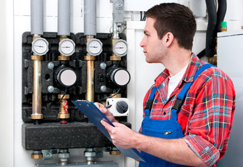 Technician servicing heating boiler