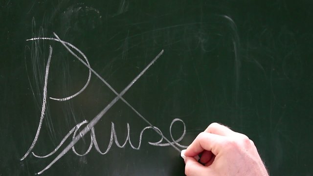 Eine Hand streicht Pause auf einer Tafel durch da Pausenende
