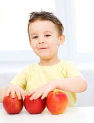 Fototapeta premium Portrait of a happy little boy with apples