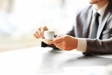 Businessman's hands working at a table, coffee