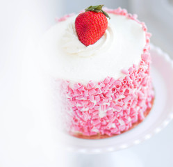 Strawberry cake with white cream on wooden background