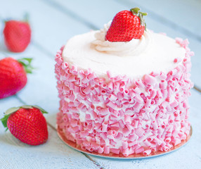 Strawberry cake with white cream on wooden background