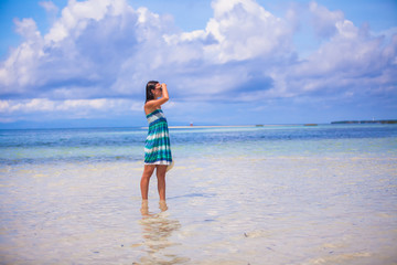 Fototapeta na wymiar Young woman enjoying the holiday on a white, tropical beach at