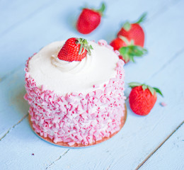 Strawberry cake with white cream on wooden background