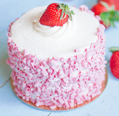 Strawberry cake with white cream on wooden background