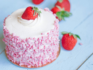 Strawberry cake with white cream on wooden background
