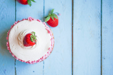 Strawberry cake with white cream on wooden background
