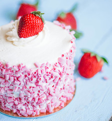 Strawberry cake with white cream on wooden background