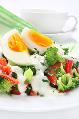 Salad with broccoli,  egg and sauce with yogurt and garlic