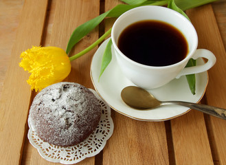 Chocolate cake, coffee cup and yellow tulip