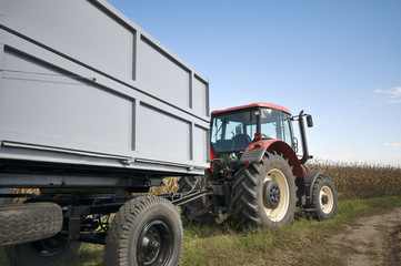 Tractor and trailer by corn field