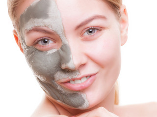 Skin care. Woman applying clay mask on face. Spa.