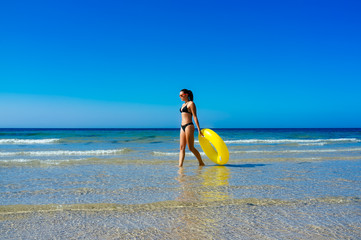 Beach Girl Walking with Yellow Float in Cadiz Beach