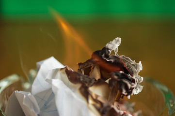 Burning paper in a glass ashtray close up