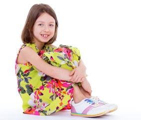 young girl sitting hugging legs