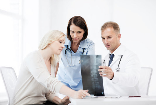 doctors with patient looking at x-ray