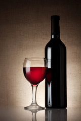 Fototapeta na wymiar Glass of red wine with a bottle