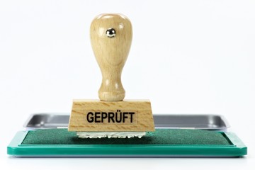 Stempel GEPRÜFT mit Stempelkissen isoliert auf weißem Hintergrund
