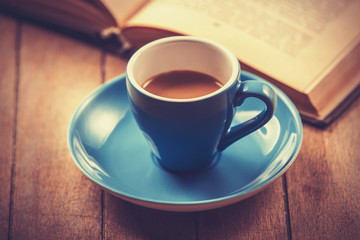blue cup of the coffee and vintage book.