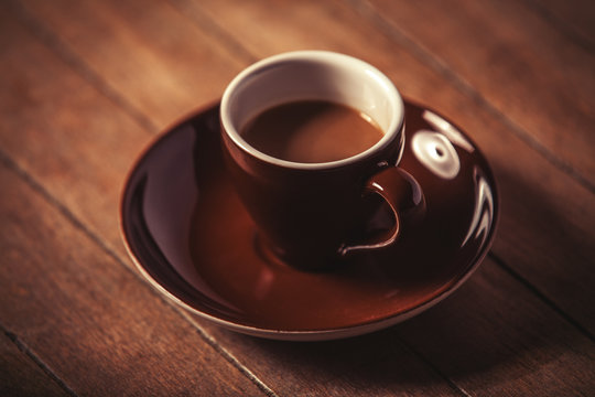 Little cup of the coffee on a wooden table