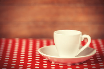 Cup of a coffee on polka dot cover.
