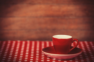 Cup of a coffee on polka dot cover.