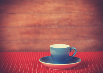 Cup of a coffee on polka dot cover.
